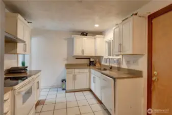 Kitchen with tile floors and solid surface counters