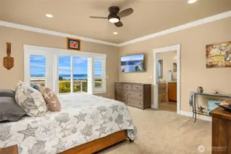 Wake up to water views and the mountains in the spacious primary suite featuring plantation shutters, crown molding, ceiling fan, and private ensuite bath.