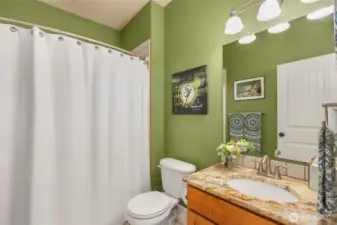 The main level guest bathroom located off the living room is a full bath, offering added convenience for guests.