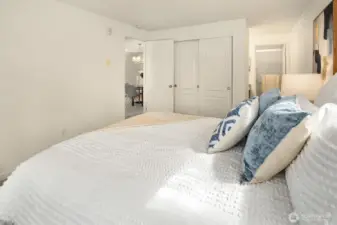 Another view of the primary bedroom showcasing the large three-panel closet and the ensuite bathroom to the right