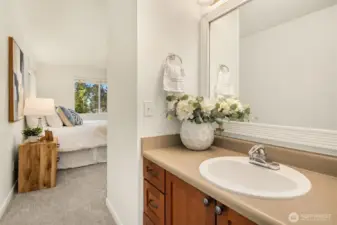 Perspective from the primary bathroom vanity into the primary bedroom, highlighting the connected layout