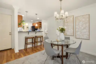 The dining area is anchored by a beautiful modern chandelier, adding warmth and style to the space