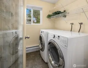 Utility room with generous storage that doubles as an overflow pantry, complete with full-size W/D.