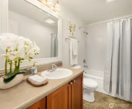 The secondary bathroom offers a tub/shower combo and a spacious cherry-cabinet vanity