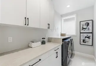 Downstairs laundry with natural light, run of counter space & upper & lower cabinets.