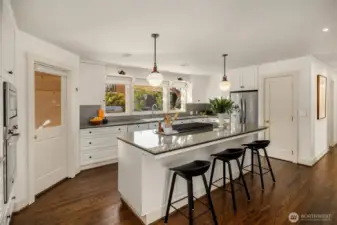 As if there's not enough storage, a walk-in pantry is tucked conveniently to the right of the new fridge.  Bar seating adds to the abundance of choices for where to perch in this delightful space.  Let's take a quick look out back before heading upstairs.