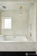 The stunning statement pendant hanging over the tub is an original Josef Hoffman design from the 1900's, imported from Austria.