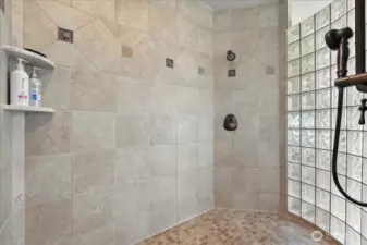 The primary suite boasts a 2-sided fireplace next to a spacious jetted soaking tub, walk-in shower, and large walk-in closet.