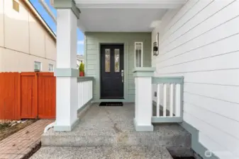 Welcoming, covered front porch with new exterior lighting, freshly painted front door, and new door handle!
