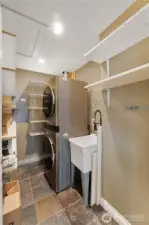 In the hallway to the left you'll find the utility room with plenty of shelves and room for a full stack washer and dryer. The tankless waterheater sits right beyond the w/d.