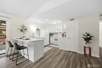 Kitchen with bar seating area, pantry closet off to the right of kitchen and sliding door out to the backyard to the left of kitchen next to dining room.