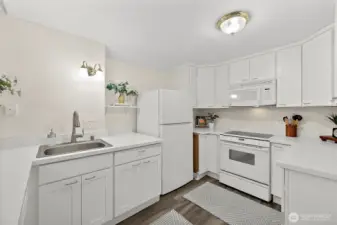 Kitchen complete with stainless sink, traditional refrigerator, stove/range, above stove microwave, and dishwasher