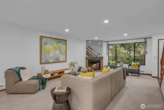 The living room lives large.  Can lighting, big picture window lots tons of light in and the wood burning fireplace ties the space together.