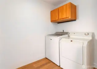 Bright laundry room with extra storage cabinets.