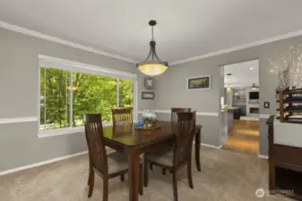 A generously sized dining room trimmed with stylish crown molding and classic chair rail.