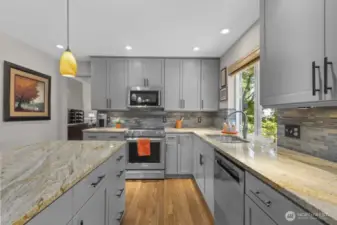 With sleek granite countertops, a stylish tile backsplash, and thoughtful lighting, this kitchen blends modern function with designer flair.