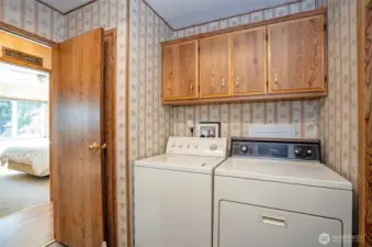 Convenient utility room with built-in cabinetry for extra storage.