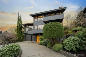 This striking residence offers exceptional functionality paired with refined curb appeal. The garage features an RV size door, an integrated shop, and generous storage throughout. Fresh exterior paint and thoughtfully designed low maintenance landscaping with sprinkler system create a clean and elegant first impression. The circular drive provides parking for four cars and enhances everyday convenience. A new roof with a transferable warranty adds peace of mind. Multiple view decks extend the living spaces including one off the family room, one off the dining room, and a private deck off the primary bedroom. Behind the home, a large deck opens from the pool room and a covered deck connects to the family room, creating seamless indoor outdoor living. The yard is mostly fenced with a gated entrance leading to the parking area at the kitchen and main floor level.