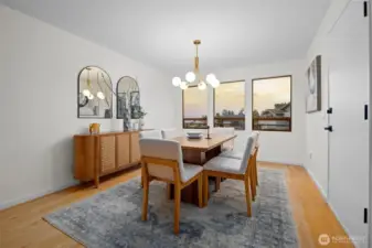 The formal dining room is an inviting place to gather for dinners with loved ones or to host guests with elegance. A wall of beautifully placed windows bathes the room in natural light, creating an uplifting setting for everyday meals and special occasions. A sophisticatedly modern chandelier adds a graceful focal point and elevates the room with a touch of understated luxury. A door leads directly to the view deck, making it easy to extend your meals and conversations outdoors.