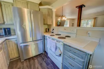 Kitchen with stainless fridge  next to stove for easy cook prep.