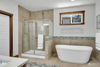 Beautiful tiled primary suite bathroom with shower & soaking tub.