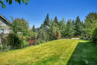 Meticulously maintained yard and gardens with a variety of colorful plantings, fruit trees and berries.