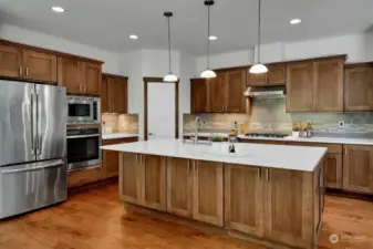 Gourmet kitchen with huge center island, quartz countertops, upgraded soft close cabinetry & stainless appliances.