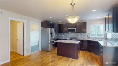 Kitchen with island and breakfast bar opens to dining space & living room