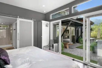 Primary bedroom w/ sliding doors to the outside.