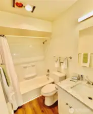 Gleaming bathroom. Chrome fixtures, toilet, sink, cabinet, lighting & mirror cabinet are new!