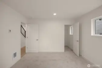Photos of model home with similar finishes & floor plan. The lower-level bedroom with a walk-in closet offers flexibility as a guest suite, gym, or additional office space.