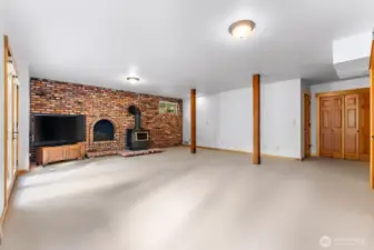 Bonus room in walkout daylight basement. Well lighted. Closet. Utility room and storage. Wood fireplace is freestanding. Real vintage brick. Electric heat.