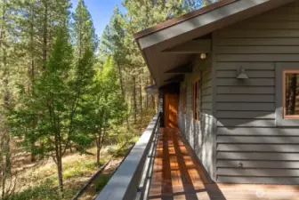 Covered wood deck walkway on main level of the home.