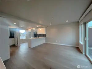Great room/kitchen with slider to right to spacious desk & door to left to powder room
