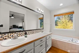 Primary bathroom double sinks with large tub.