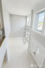 View from the loft area to the main floor, showcasing high ceiling entrance and the living room