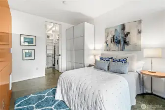 The bedroom features a wardrobe with built-in drawers as well as a walk-in closet.