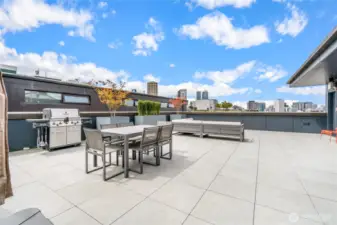 The well-appointed rooftop deck includes a seating area with fire feature, dining table, BBQ and views!