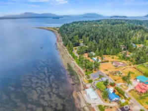 Aerial view looking west toward the end of Samish Island, with Camp Kirby visible in the distance—highlighting the property's unique location and proximity to this beloved local landmark.