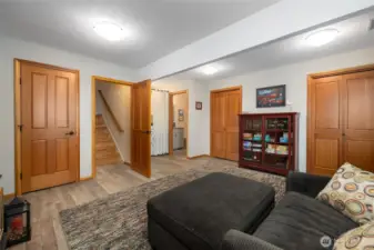 Another view of the family room with wood doors, lots of storage space, garage access and exterior door leading to the wonderful outdoor spaces.