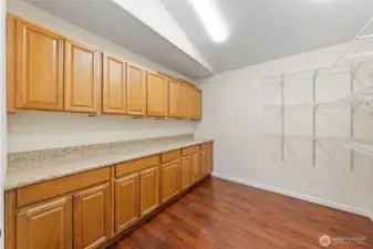 Oversized pantry room with cabinetry, counters, and storage racks.