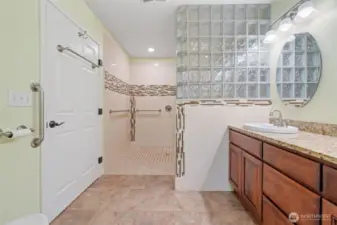 Accessible shower with wall-mounted grips for comfort and safety.