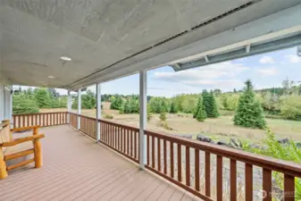 Covered deck overlooking the yard and pond - a quiet spot to unwind.