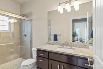 Main floor bathroom features a walk in tile surround shower. Cabinet space grants additional storage for personal items.