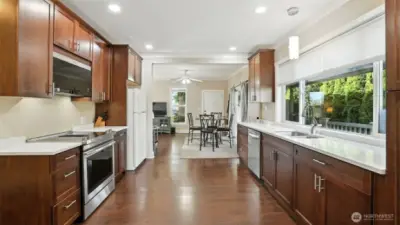 Updated kitchen with warm wood cabinetry, Quartz countertops, & newer appliances