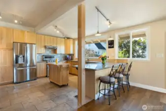 Wide open kitchen with heat up bar and dual fuel stove, (gas cooktop with electric oven”. Beautiful tile and countertops with lots of cabinets, storage and lighting.