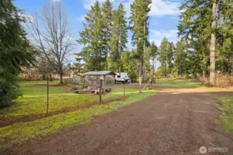 View of private, separate RV space; complete with 350 gallon holding tank; delightful outdoor living includes lawn area and fully covered entertainment and storage building.
