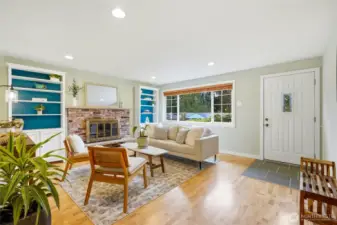 The formal living room with hardwood floors and a brick fireplace is a great place to gather.
