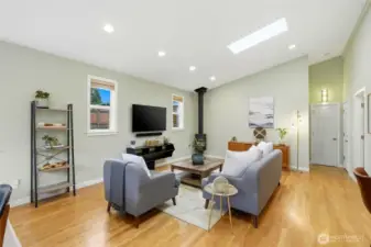 Open to the kitchen, the great room has vaulted ceilings, hardwood floors, and a wood stove in the corner to keep things cozy.