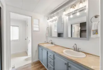 main home primary bath featuring a large vanity & ample storage